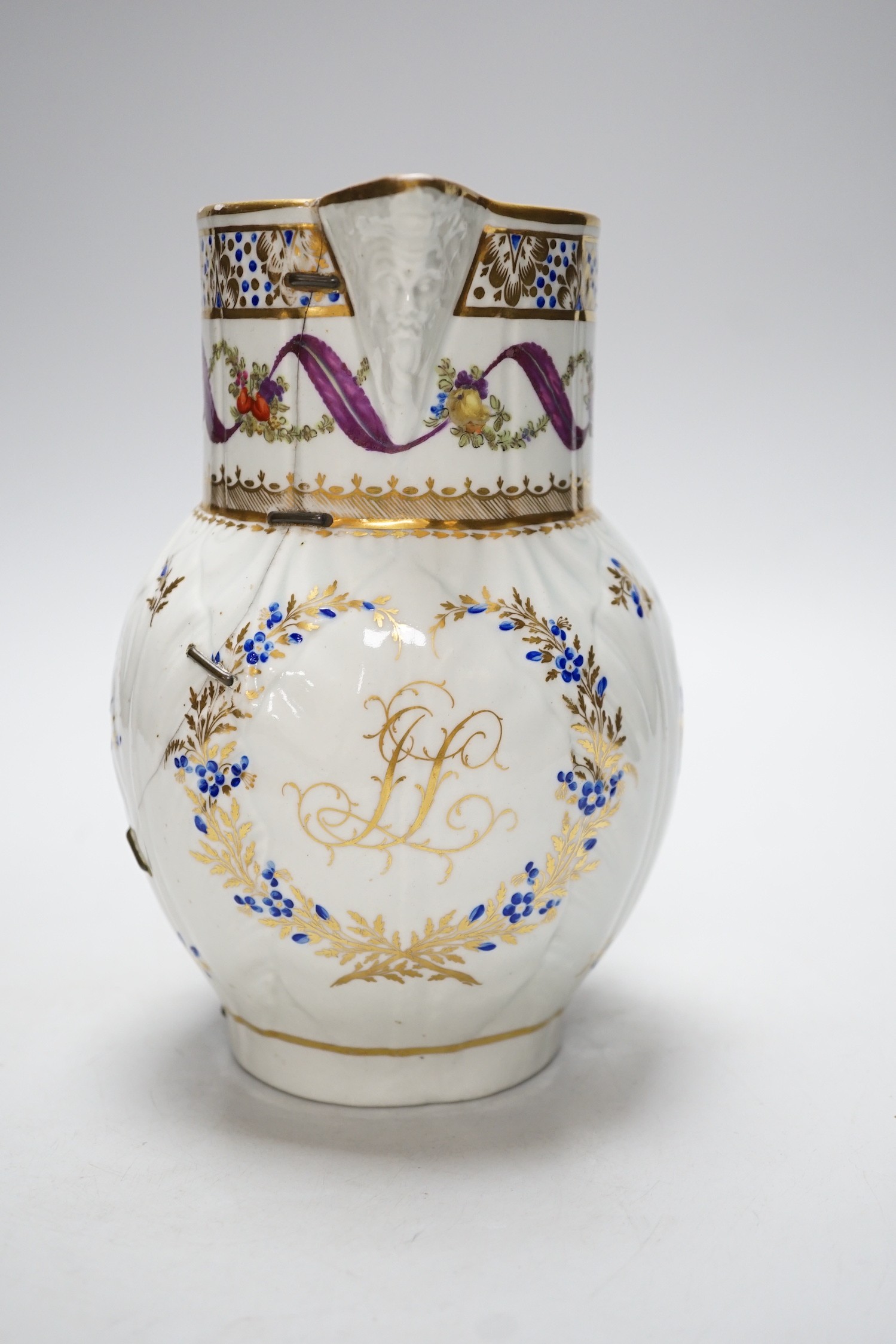 An 18th century Caughley very rare polychrome mask jug, elaboratley painted and gilded with two initials in a dry blue and gilt wreath, Gittins Col., Pictured Caughley Bicentenary Exhibition 1999, with labels, 19cms high